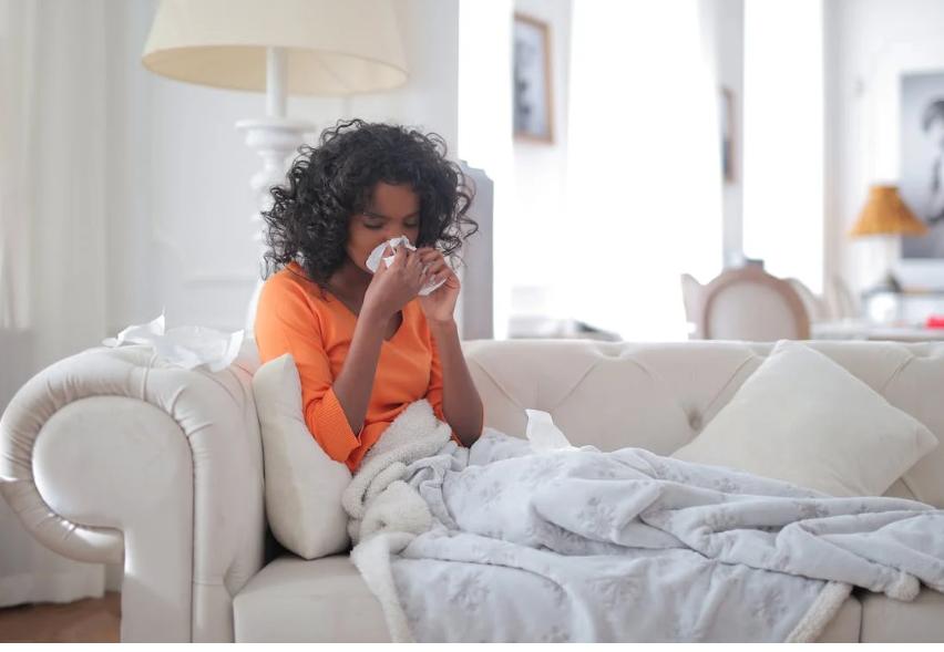 Woman Sneezing and laying on couch